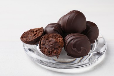 Photo of Many delicious chocolate truffles on white wooden table, closeup