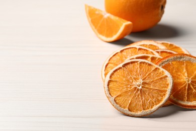 Dry orange slices on white wooden table, closeup. Space for text