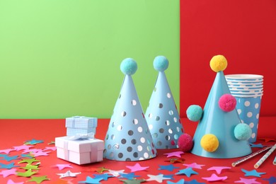 Party hats and other bright decor on color background