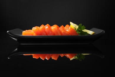 Photo of Delicious salmon sashimi served with lemon and parsley on black mirror surface