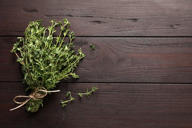 Bunch of aromatic thyme on wooden table, top view. Space for text