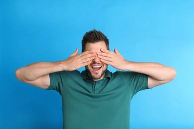 Photo of Man covering eyes while being blinded on blue background
