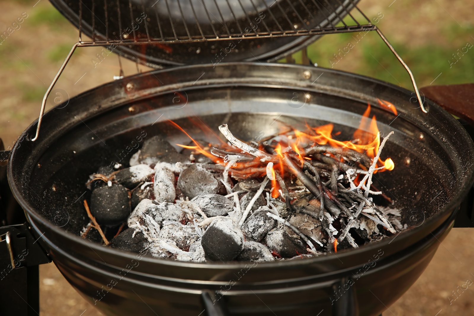 Photo of Modern barbecue grill with coals outdoors. Camping cookout