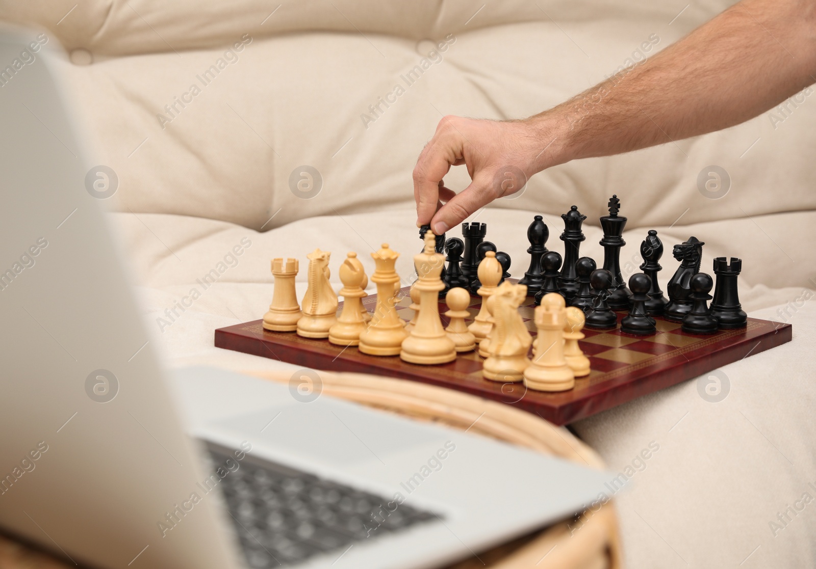 Photo of Man playing chess with partner through online video chat at home, closeup