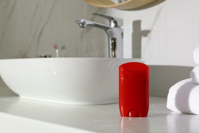 Deodorant container on light countertop in bathroom