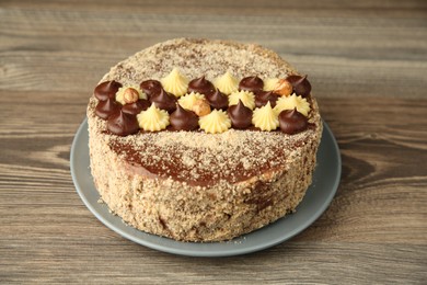 Photo of Delicious Kyiv Cake decorated with cream on wooden table, closeup