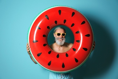 Photo of Shirtless man with inflatable ring on color background