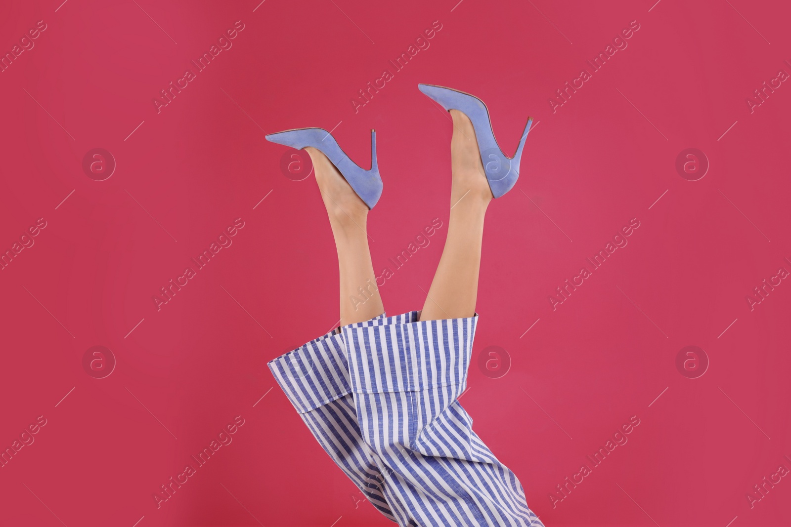 Photo of Woman in elegant shoes on crimson background