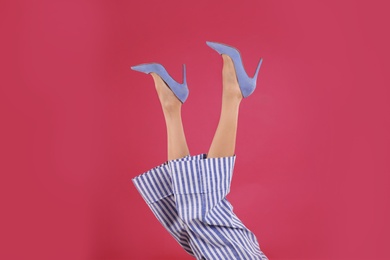 Photo of Woman in elegant shoes on crimson background