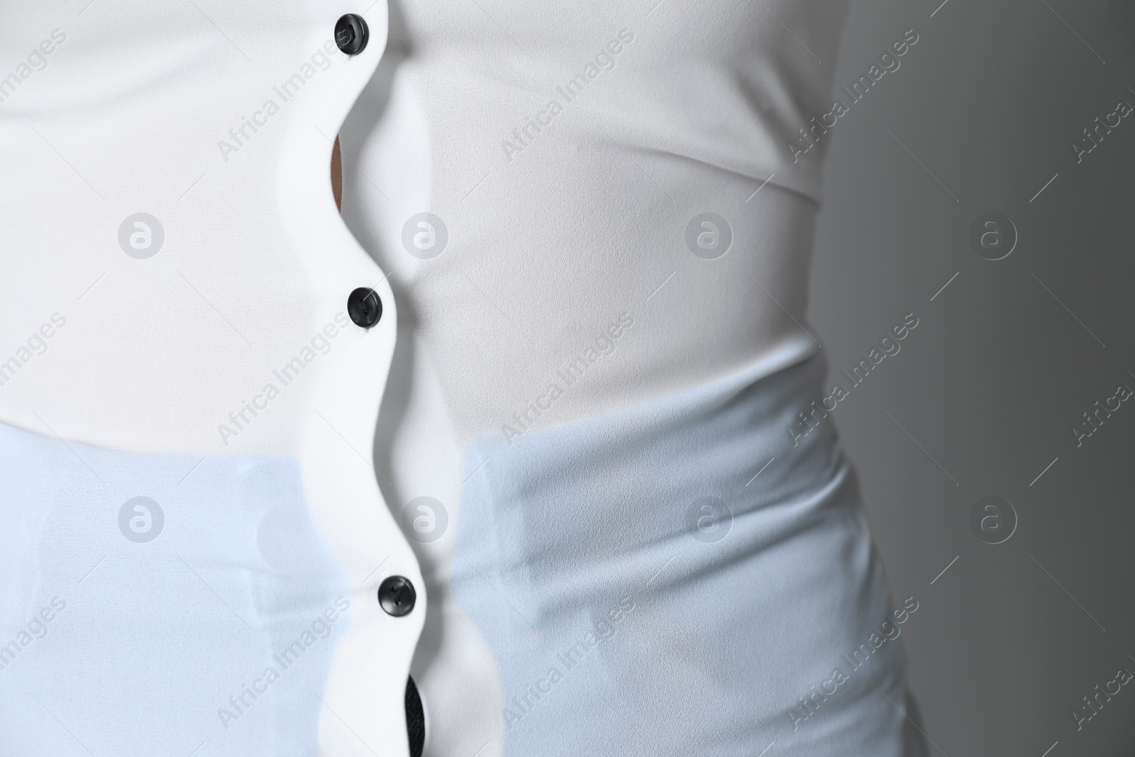 Photo of Overweight woman in tight shirt on grey background, closeup