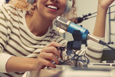 Photo of African American woman working as radio host in modern studio, closeup