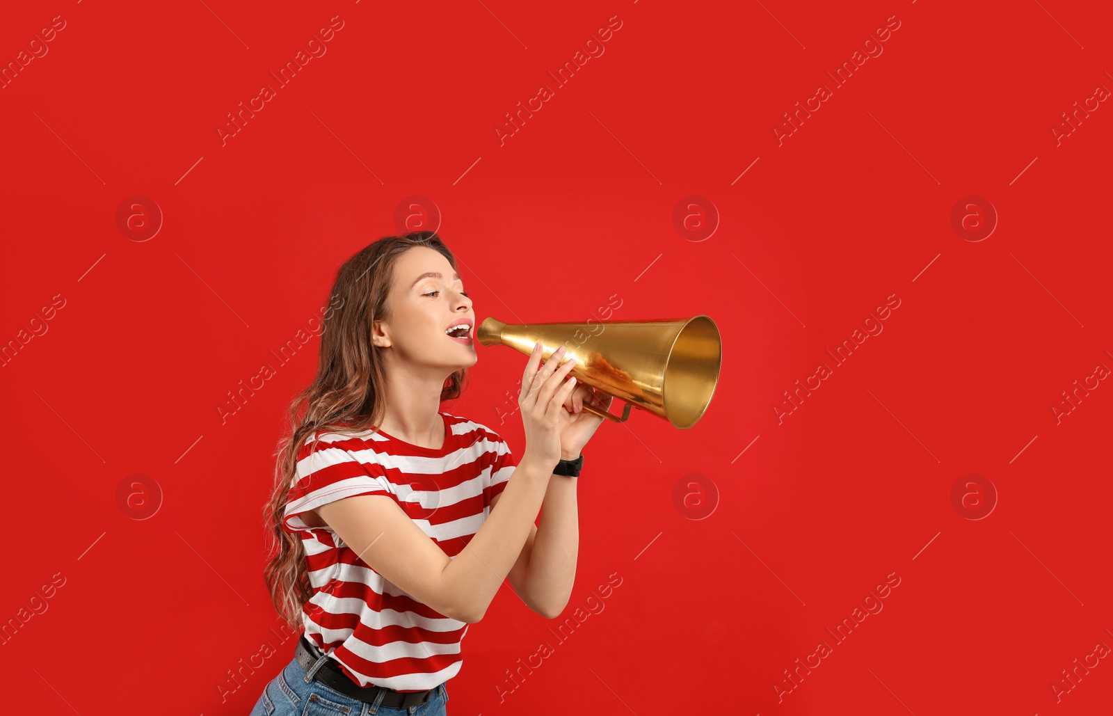 Photo of Young woman with megaphone on red background
