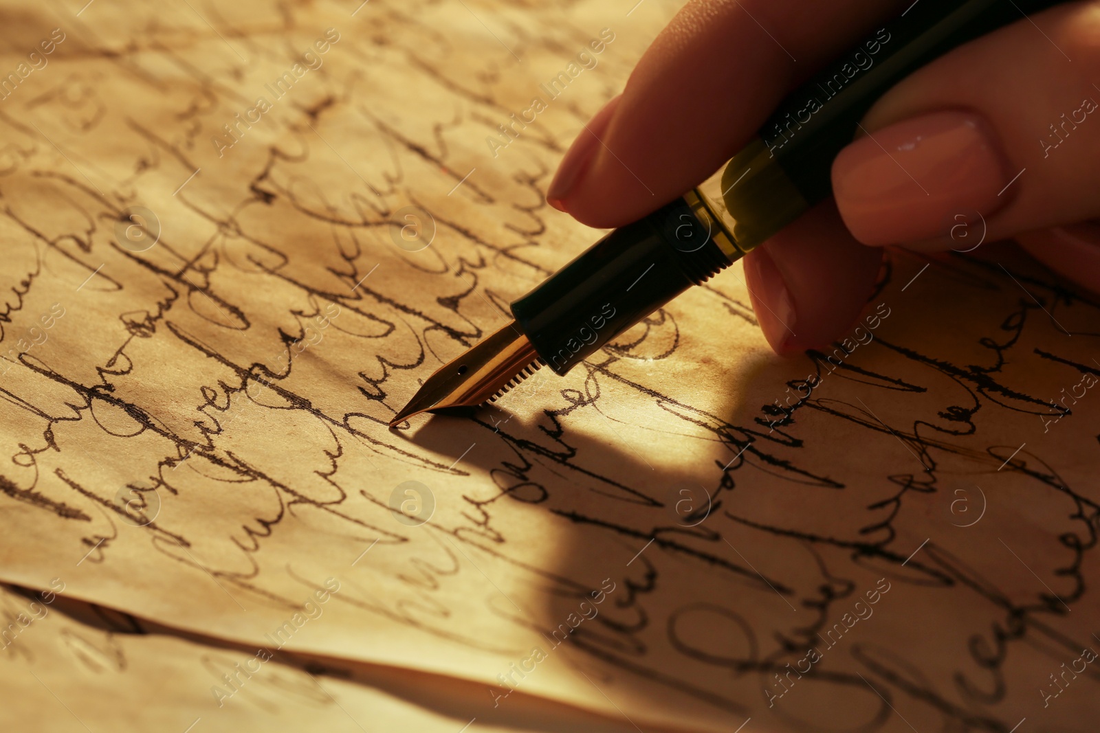 Photo of Woman writing letter with fountain pen, closeup