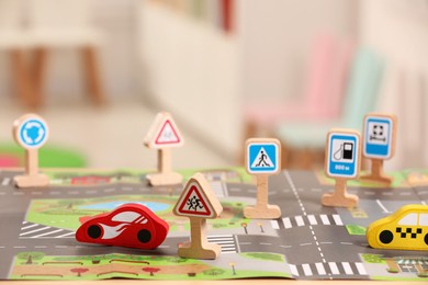 Set of wooden road signs and cars on table indoors, closeup. Children's toys