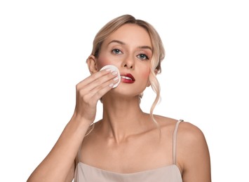 Beautiful woman removing makeup with cotton pad on white background