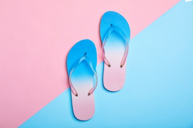 Photo of Stylish beach flip-flops on color background, top view