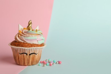 Photo of Cute sweet unicorn cupcakes on color background, space for text