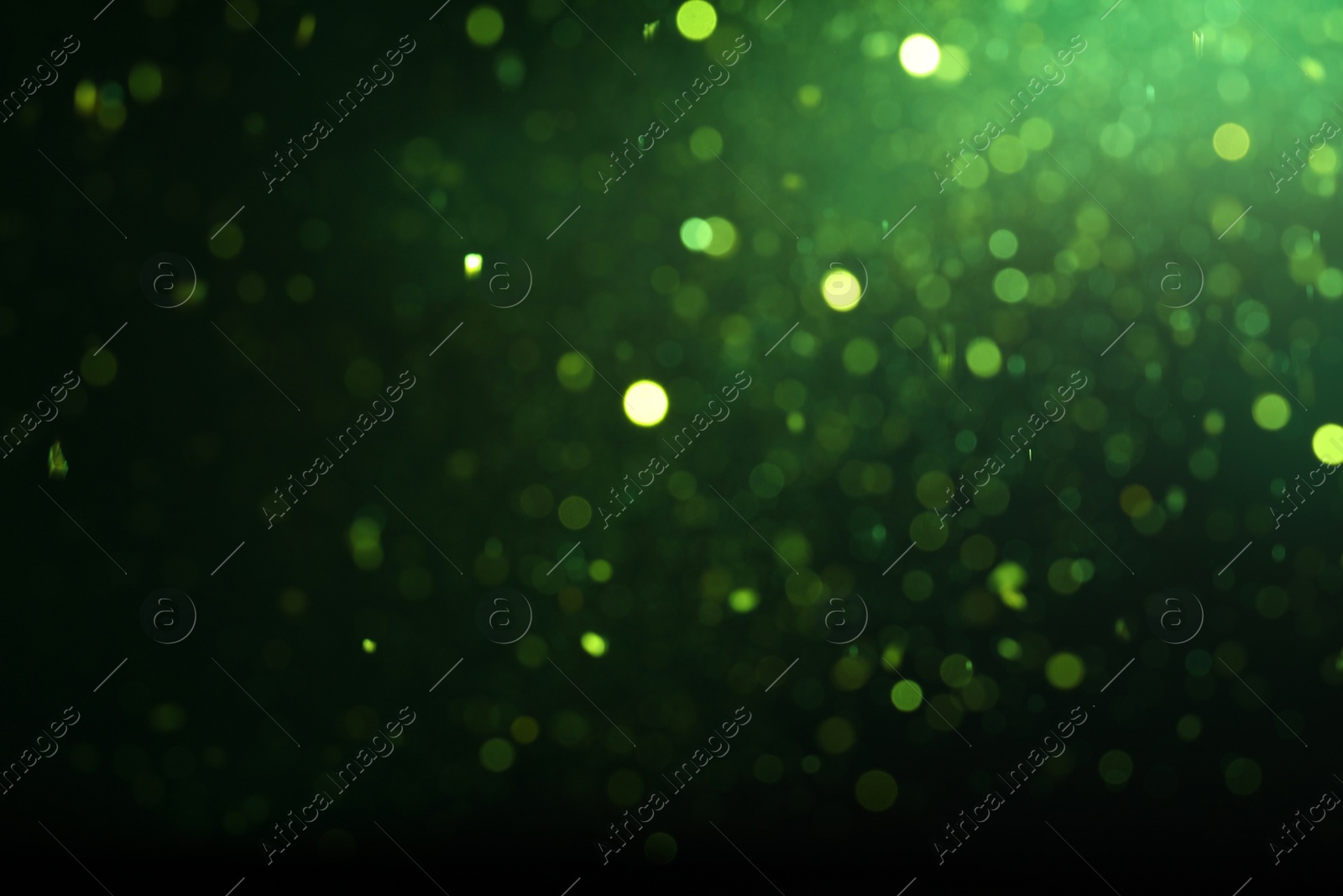 Photo of Blurred view of festive lights on green background. Bokeh effect