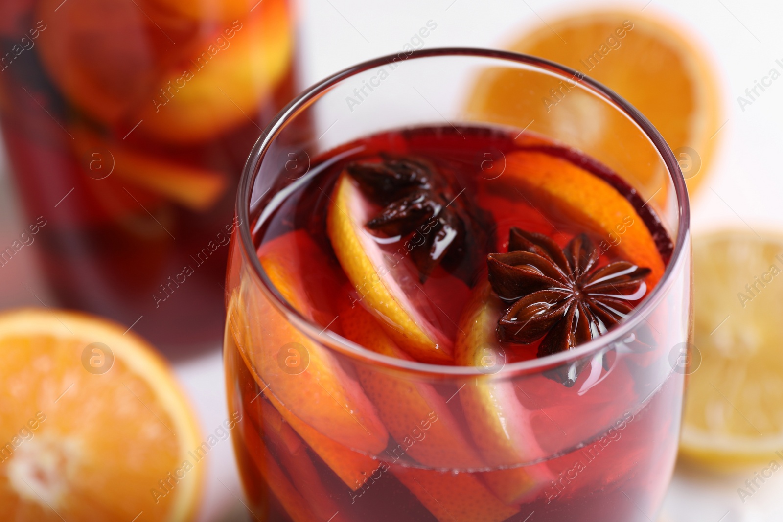 Photo of Glass of aromatic punch drink on table, closeup