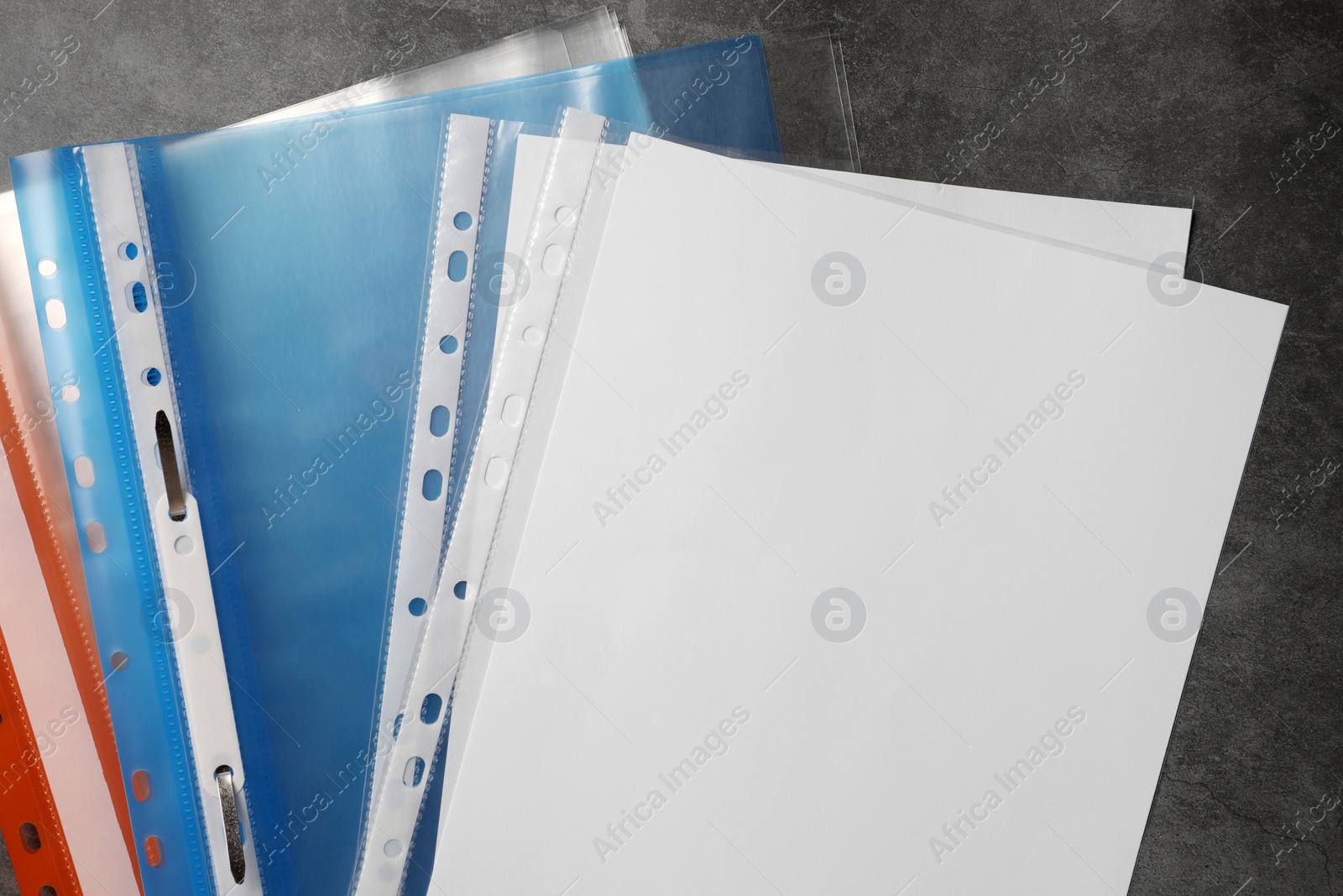 Photo of File folders with punched pockets on grey table, flat lay. Space for text