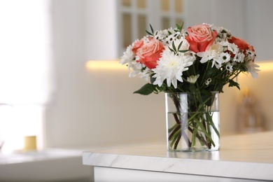 Vase with beautiful flowers on table in kitchen, space for text. Interior design