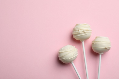 Photo of Sweet cake pops on pink background, flat lay. Space for text