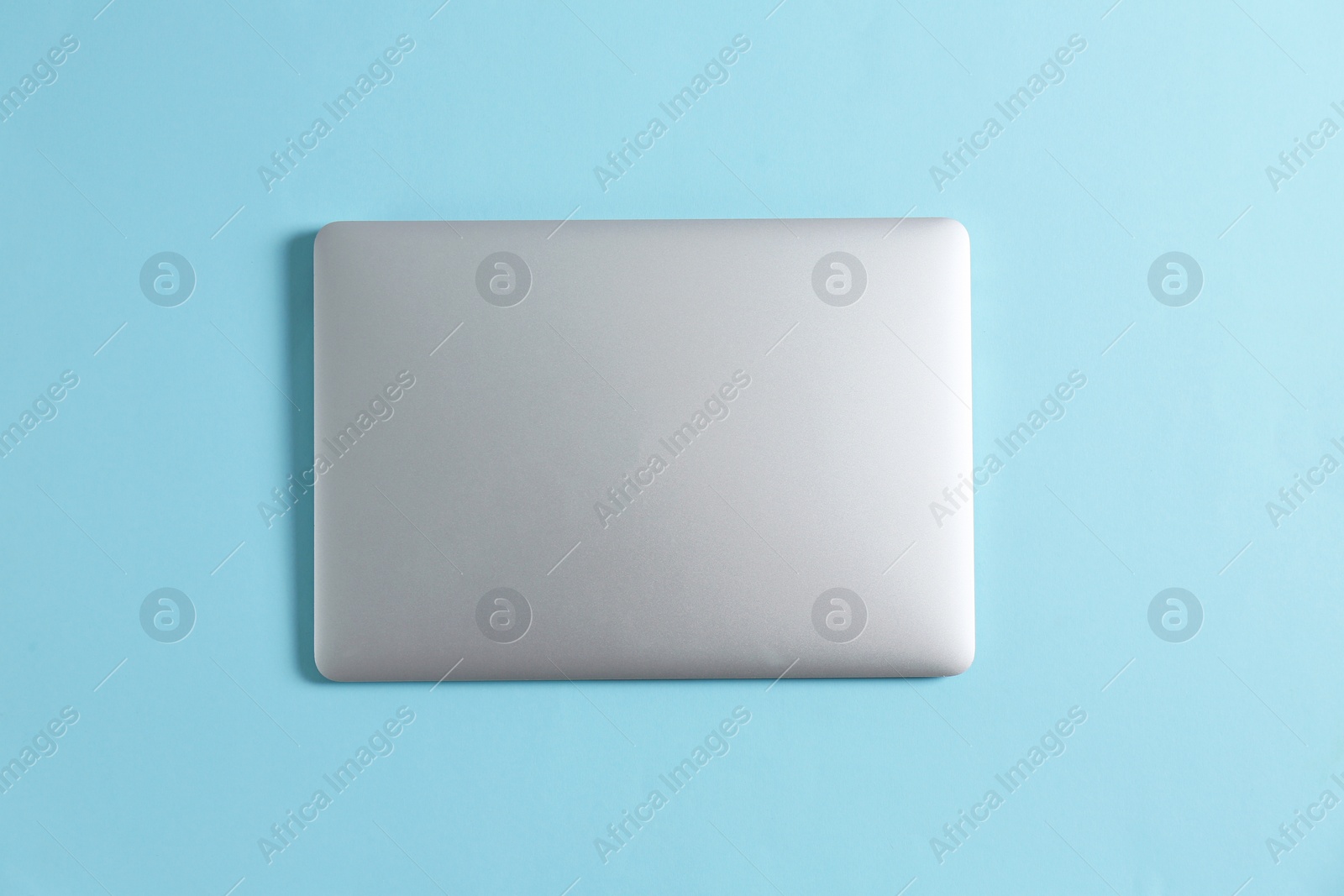 Photo of Modern laptop on color background, top view