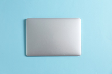 Photo of Modern laptop on color background, top view