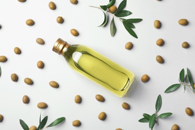 Flat lay composition with bottle of olive oil on light background