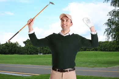 Image of Young man with golf club on green course 