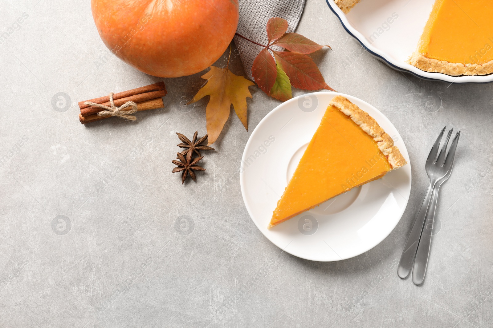 Photo of Flat lay composition with piece of fresh delicious homemade pumpkin pie on gray background
