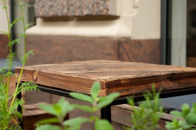 Photo of Wooden table near building outdoors, closeup view