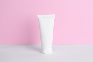 Photo of Tube of cream on color background. Body care product