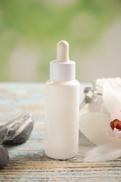 Photo of Composition with spa cosmetic and orchid flower on light wooden table, closeup