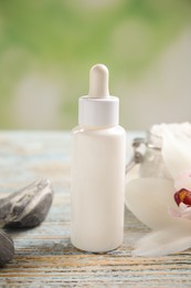 Composition with spa cosmetic and orchid flower on light wooden table, closeup