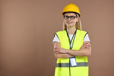 Photo of Engineer with hard hat and badge on brown background, space for text