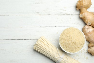 Flat lay composition with rice noodles on white wooden  table, space for text