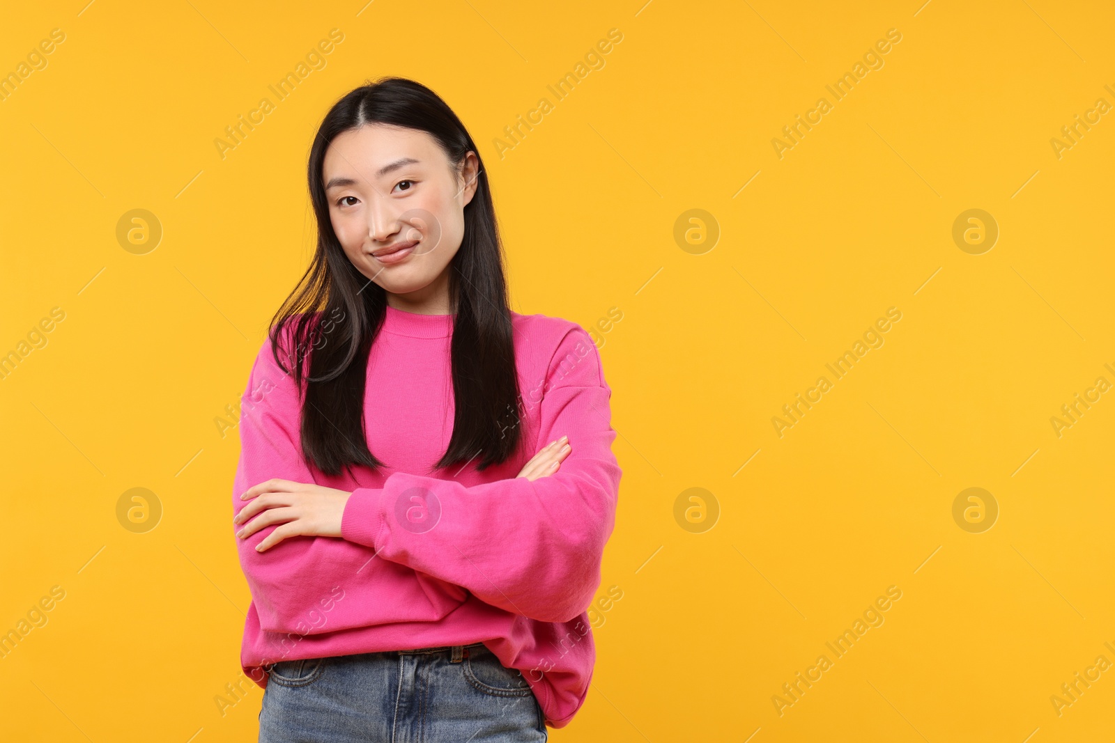 Photo of Portrait of beautiful woman on orange background. Space for text