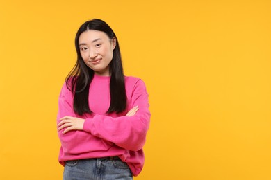 Photo of Portrait of beautiful woman on orange background. Space for text