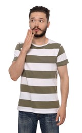 Embarrassed man covering mouth with hand on white background