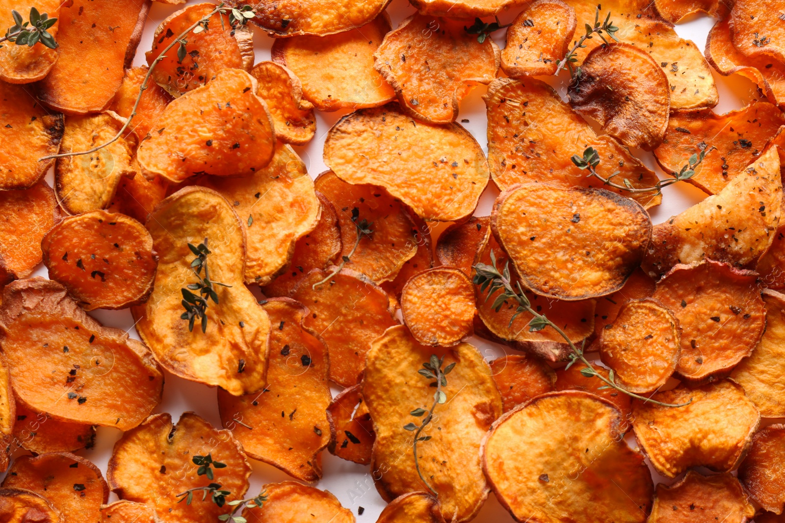 Photo of Sweet potato chips with herbs on white background, top view