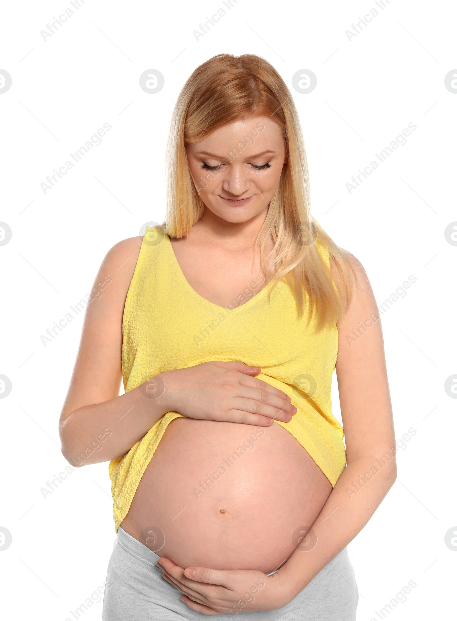 Photo of Beautiful pregnant woman showing her tummy on white background