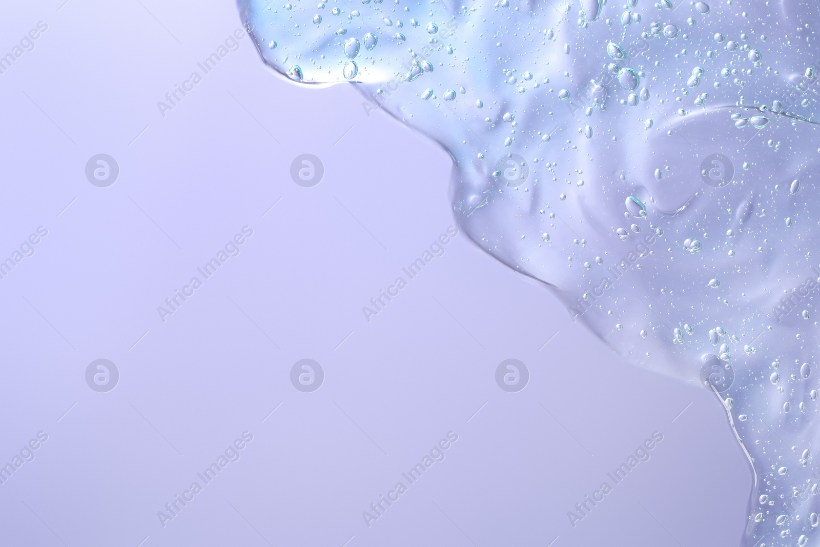 Photo of Transparent cleansing gel on violet background, top view with space for text. Cosmetic product