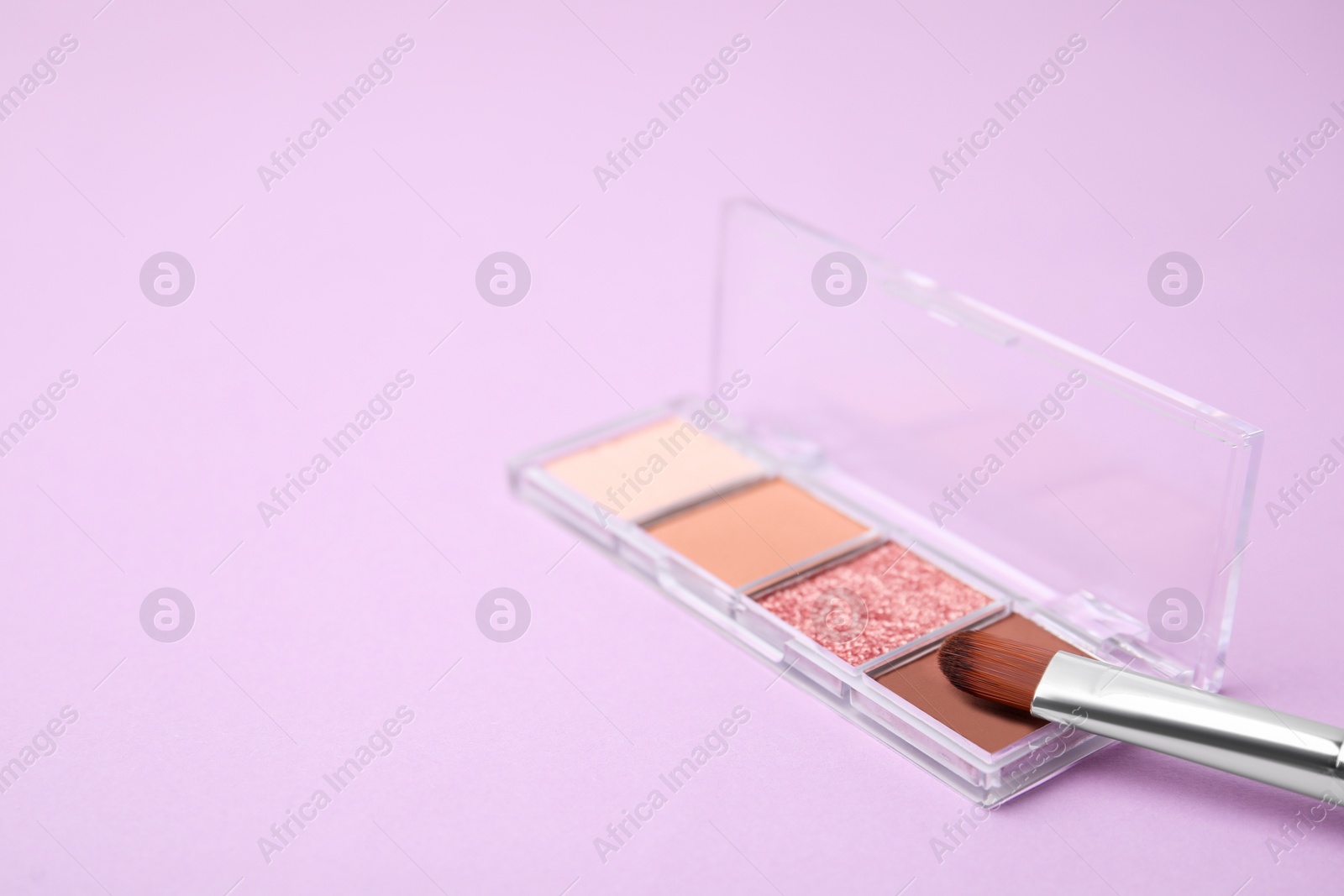 Photo of Beautiful eye shadow palette and brush on lilac background. Space for text