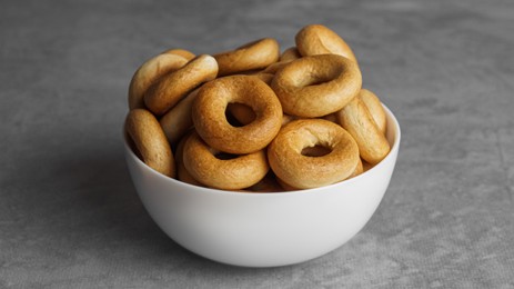 Bowl of tasty dry bagels (sushki) on grey table, closeup