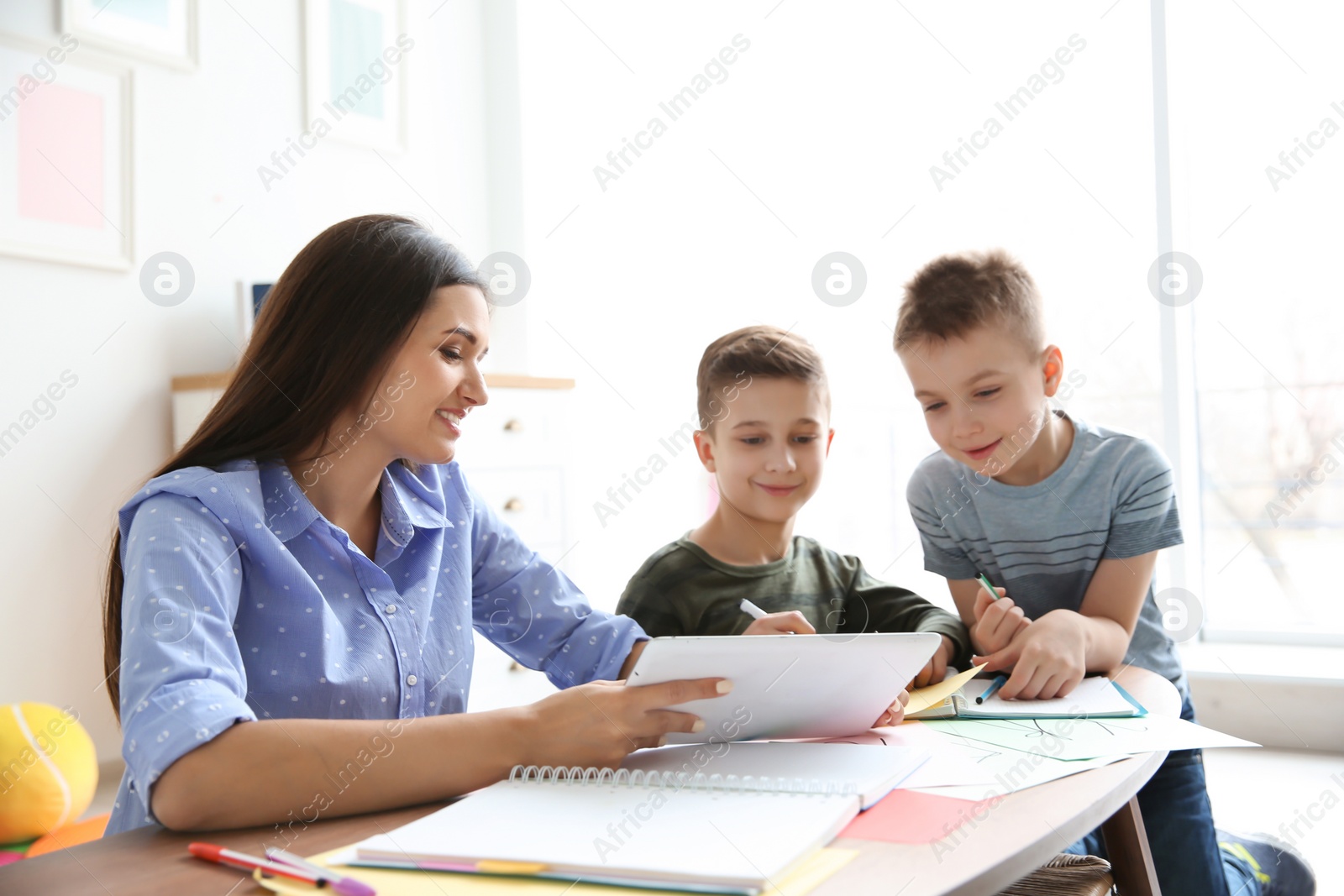 Photo of Cute little children with teacher in classroom at school