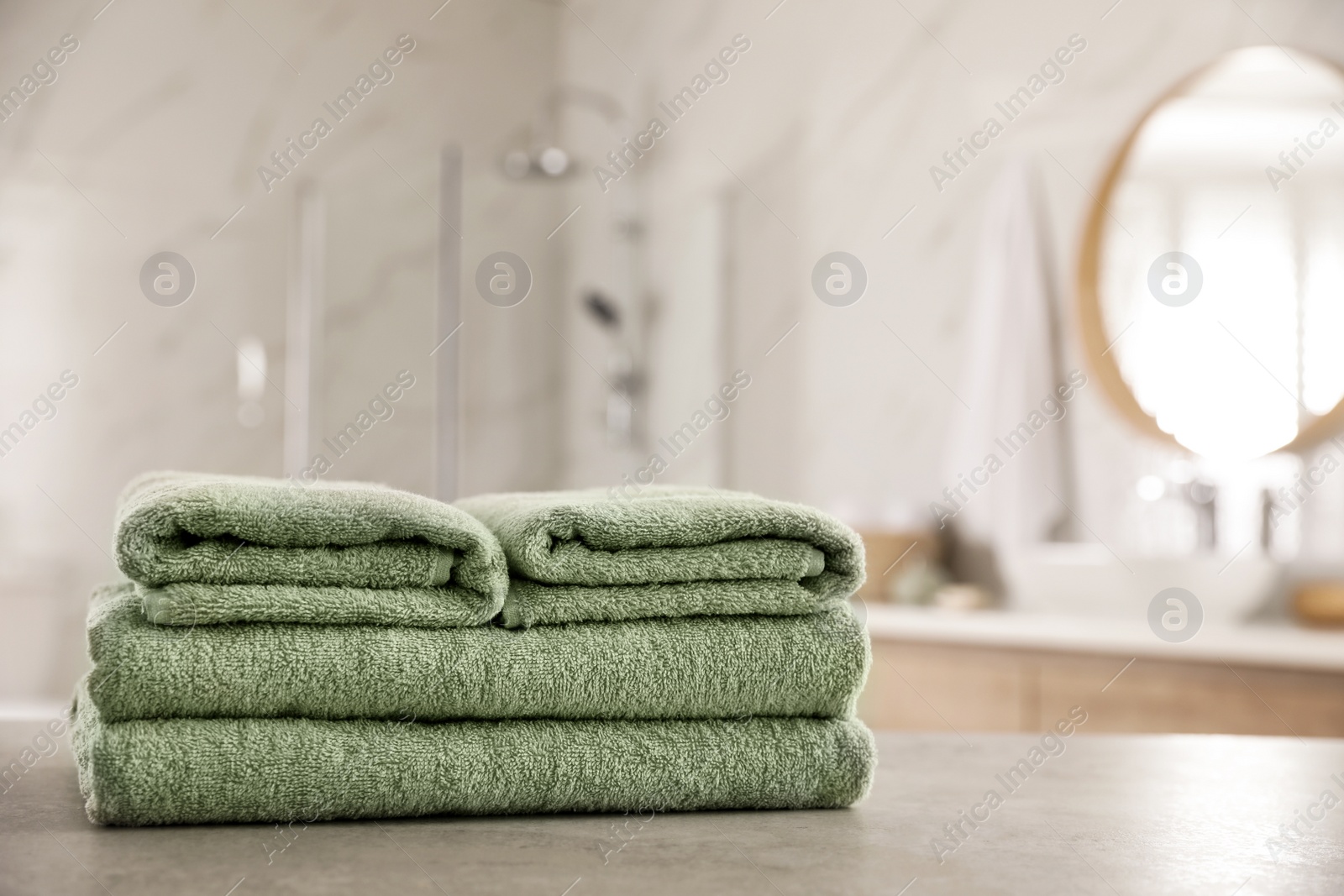 Photo of Stack of clean towels on table in bathroom