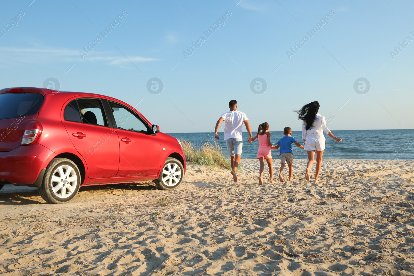 Photo of Family running on sandy beach. Summer trip