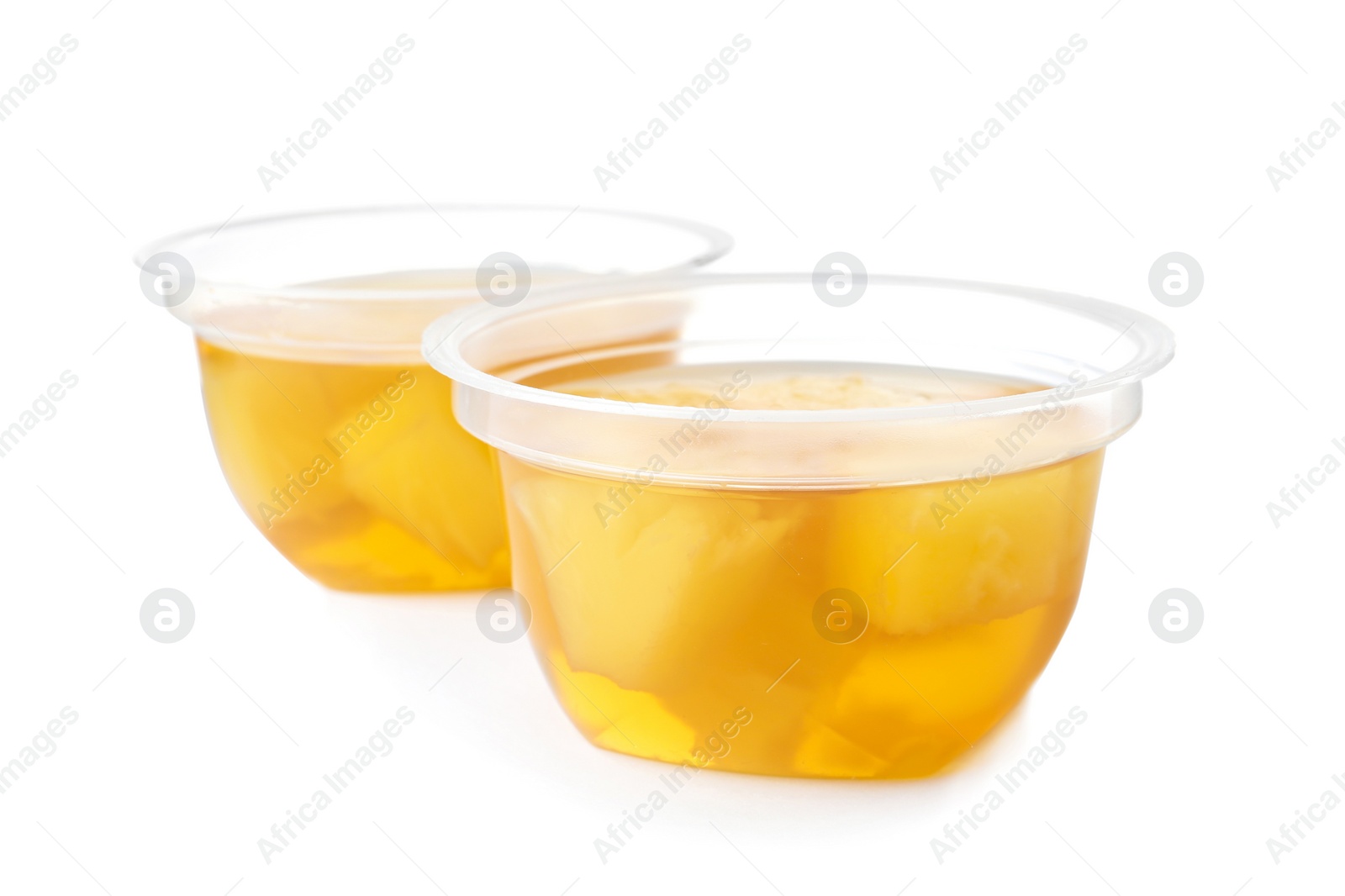 Photo of Tasty jelly desserts with slices of fruit in plastic cups on white background