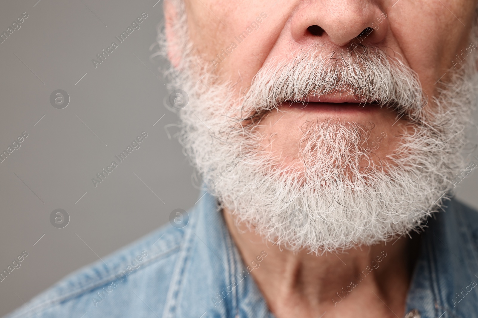 Photo of Man with mustache on grey background, closeup. Space for text